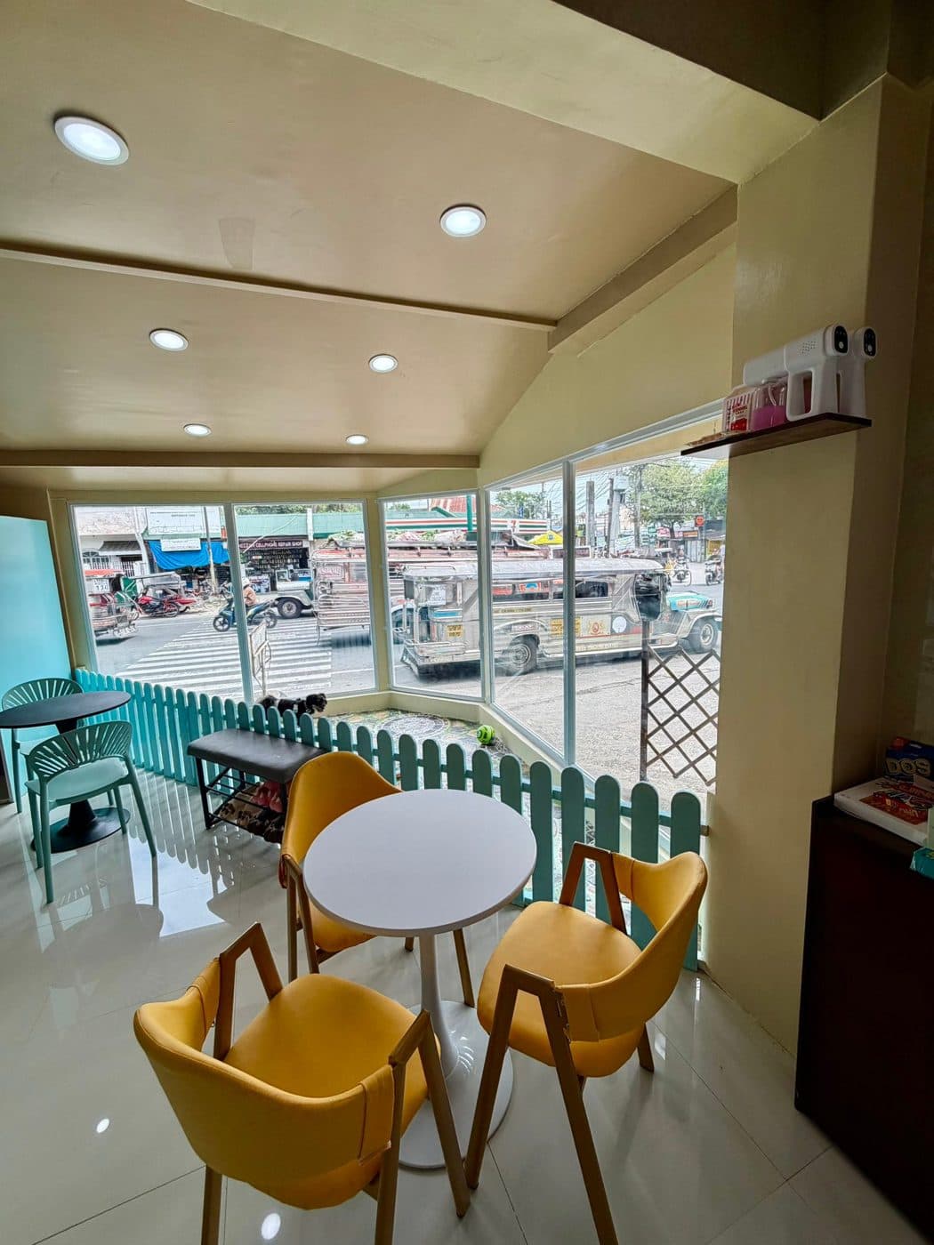 Yellow chairs and round tables by the Hoomans Café windows